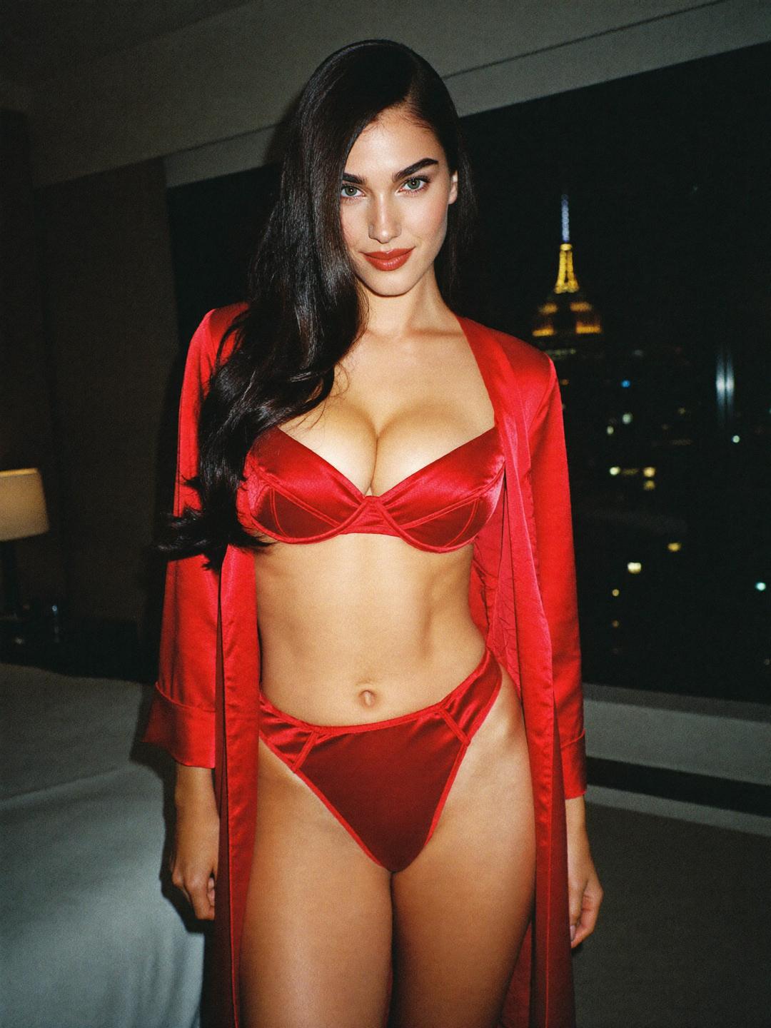 Ava in red satin lingerie and a red robe in a Manhattan hotel suite at night